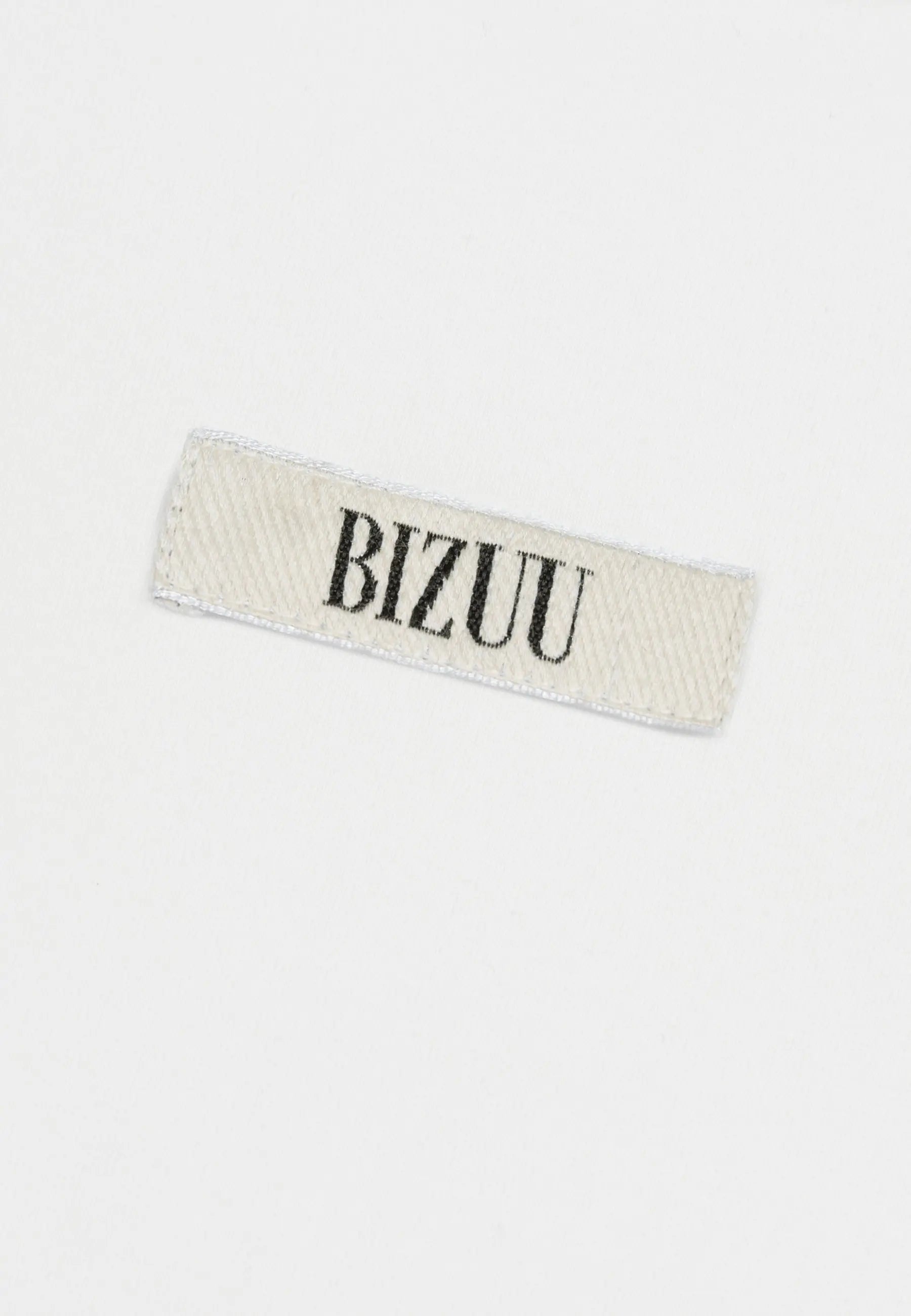 Zbliżenie na logo Bizuu na przodzie kremowego T-shirtu TISHALLE.